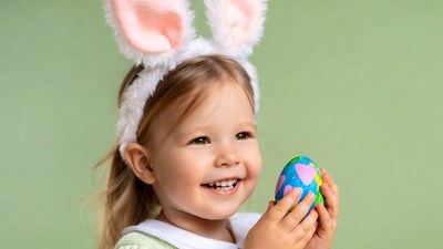 Girl with bunny ears holding Easter egg