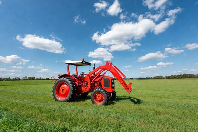 Red tractor with loader in field