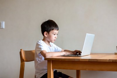 Asian boy using laptop at table