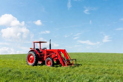 Red tractor on green field