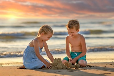 Boy and girl building sandcastle on beach