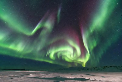 Vibrant Northern Lights over Snowy Landscape