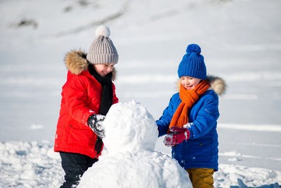 Two children building snowman
