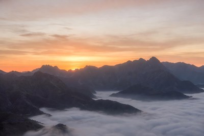 Sunrise over Mountain Peaks in Clouds