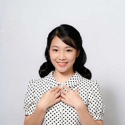 Asian woman smiling in polka dot dress