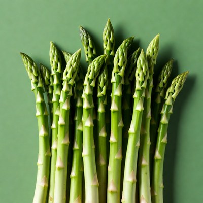 Fresh asparagus spears on green background