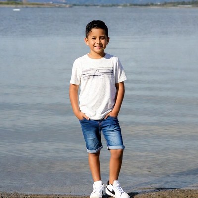 Smiling Latino boy by lake