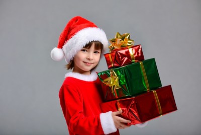 Boy holding Christmas gifts in Santa suit