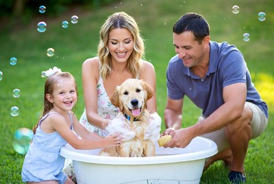 Family bathing golden retriever puppy outdoors