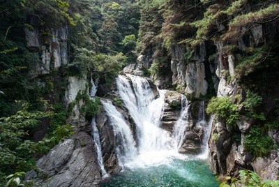 Majestic waterfall cascading in lush green valley