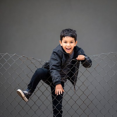 Boy smiling on chain link fence