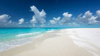 Turquoise ocean waves on white sand beach