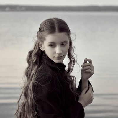 Girl by lake in black turtleneck