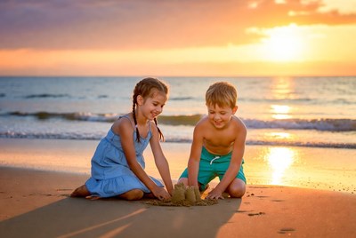 Boy and Girl Building Sandcastle at Sunset Beach