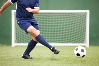 Soccer player kicking ball at goal
