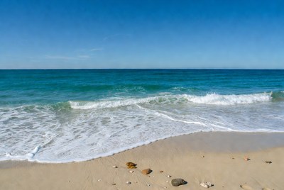 Sandy beach with turquoise waves and seashells