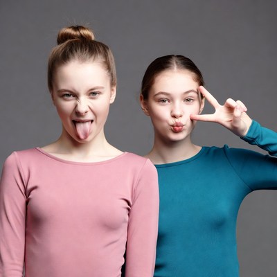 Two girls sticking tongues out with peace sign