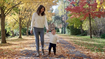 Mother holding toddler's hand in autumn park