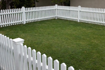 White Picket Fence Enclosing Green Lawn