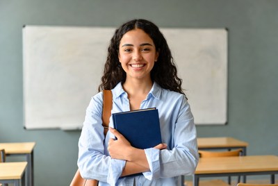 Smiling Latina teacher holding book