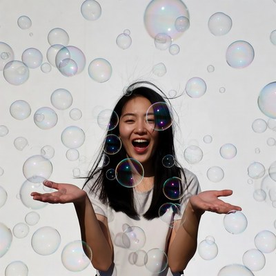 Asian woman laughing with soap bubbles