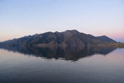 Mountains reflected in lake at sunset