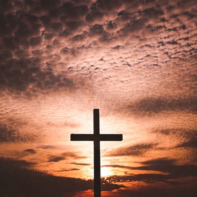 Silhouette Cross at Sunset Sky