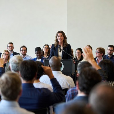 Woman speaking at podium to diverse audience