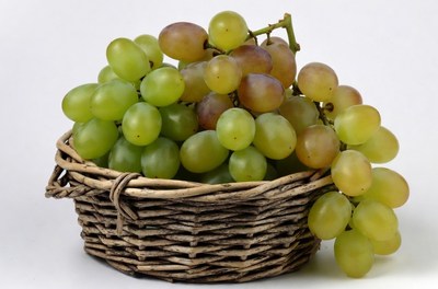 Green and red grapes in wicker basket