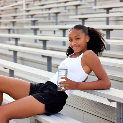 African-American girl with water bottle on bleachers