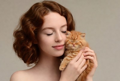 Woman holding cute orange kitten