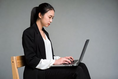 Asian woman typing on laptop