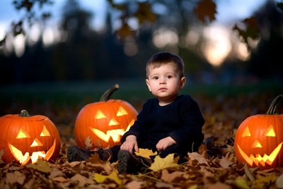 Baby boy with carved pumpkins