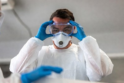 Man adjusting safety goggles in PPE