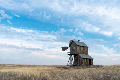 Old wooden windmill in dry grassland
