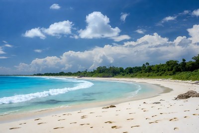 Tropical beach with footprints and turquoise waves