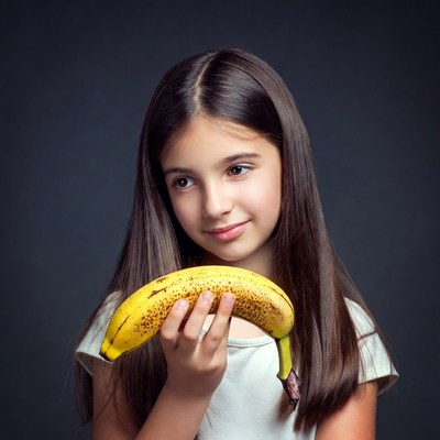 Girl holding ripe banana