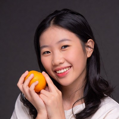 Asian girl holding orange