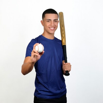 Young man holding baseball bat and ball