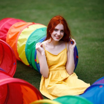 Redhead woman in colorful tunnel on grass