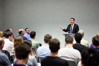 Man speaking at podium to audience