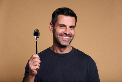 Man holding spoon smiling