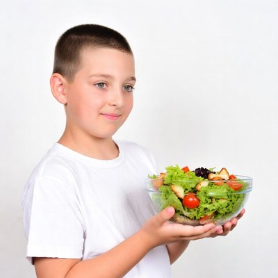 Boy holding fresh salad bowl