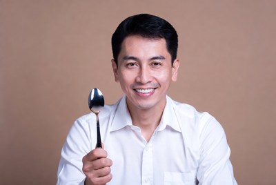 Asian man holding spoon