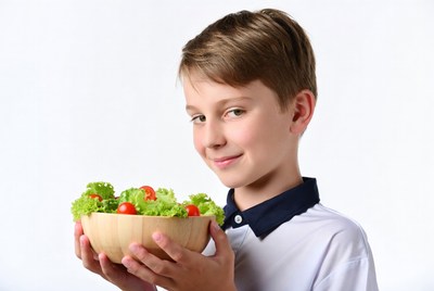 Boy holding fresh salad bowl