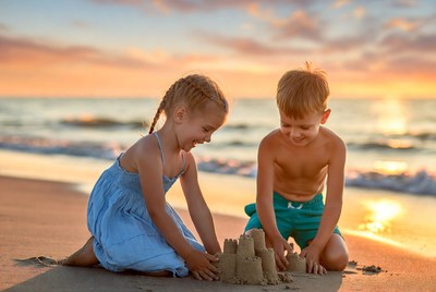 Boy and Girl Building Sandcastle on Beach
