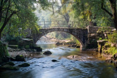 Stone Arch Bridge over Forest Stream