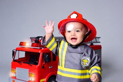 Baby boy waving in firefighter costume