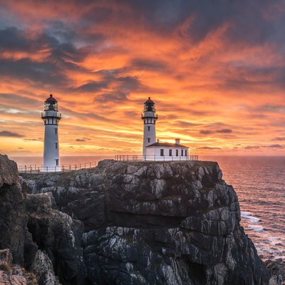Twin Lighthouses on Cliff at Sunset