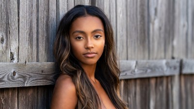 Beautiful African-American woman leaning on wooden fence